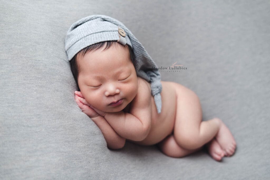 Cute baby doing a side sleeper pose in his newborn photography session