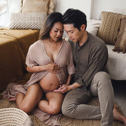 Maternity photography couple sitting pose in rustic decor setting