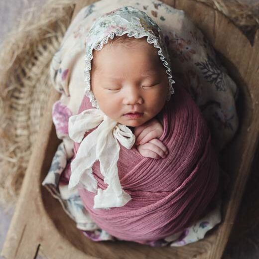Newborn photography baby in red posing in vintage dough bowl