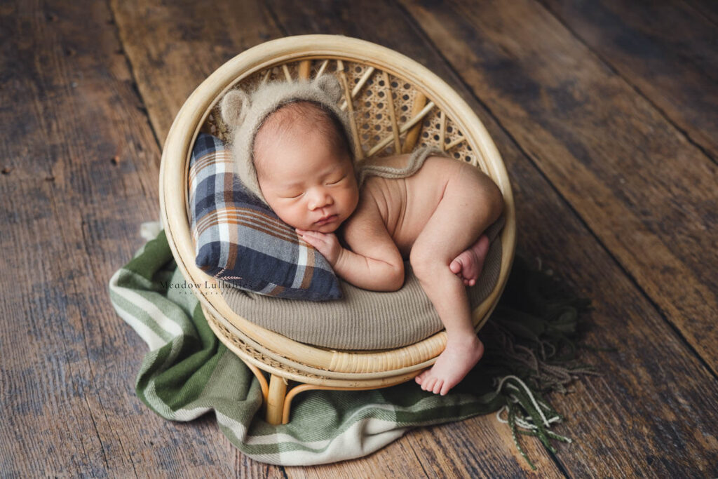 Newborn photography newborn baby posing on a vintage round rattan stool